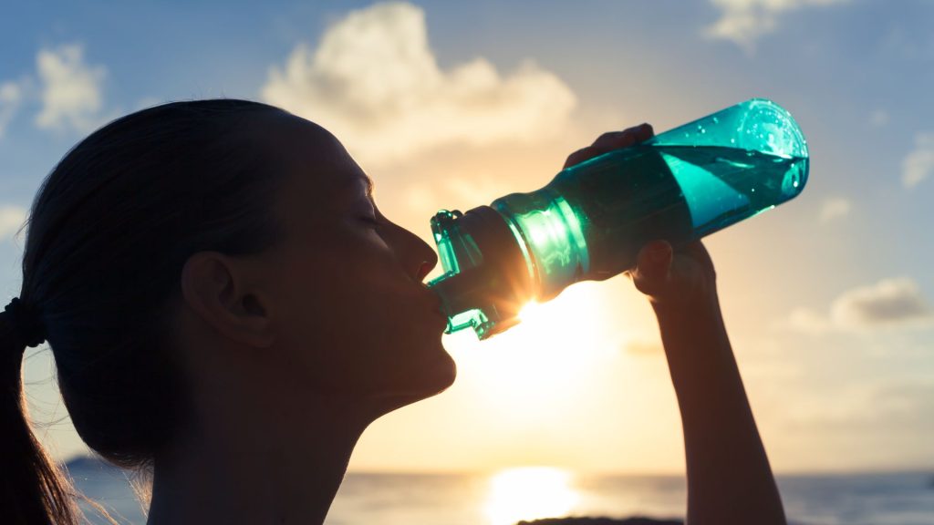 Donna con tramonto: idratazione in estate